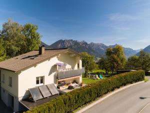 une maison sur le côté d'une route avec des montagnes en arrière-plan dans l'établissement Schallert, à Bürserberg