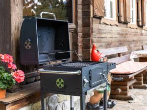 - un barbecue noir installé à l'extérieur de la maison dans l'établissement Sonnrasthütte, à Untergaimberg