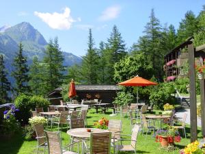 eine Terrasse mit Tischen und Stühlen mit Bergen im Hintergrund in der Unterkunft Matrei Park 55 in Matrei in Osttirol