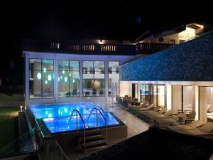 a swimming pool in a building with chairs around it at Matrei Park 55 in Matrei in Osttirol