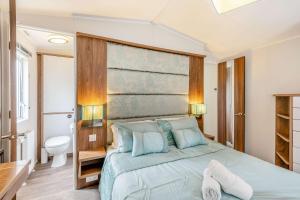 a bedroom with a large bed and a bathroom at Skyline Lodge in Lymington