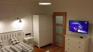 a living room with a couch and a flat screen tv at Apartamenty Solo na Molo in Sopot