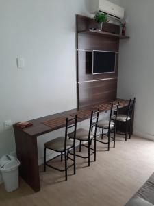 cocina con mesa de madera y sillas en Apartamento Ilha dos Patos Ingleses na Beira do Mar, en Florianópolis