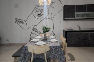 a table in a kitchen with a drawing on the wall at Netflix High Speed Internet 9pax Cinema Theme house Setiawalk with pool in Puchong