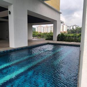 a swimming pool in front of a building at Netflix High Speed Internet 9pax Cinema Theme house Setiawalk with pool in Puchong