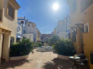 an alley with a fountain in the middle of buildings at Casa Rodasa - 2 bedrooms, roof terrace, Airco, Front-terrace, Back-Patio, communal pool, etc in Roda