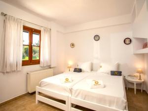 une chambre blanche avec un grand lit blanc et une fenêtre dans l'établissement Holiday Home near Beach in Afandou, à Koskinou
