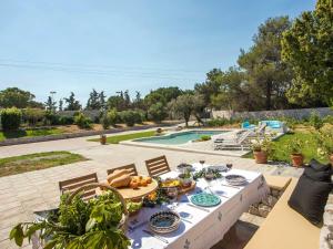 - une table avec des assiettes de nourriture à côté d'une piscine dans l'établissement Holiday Home near Beach in Afandou, à Koskinou