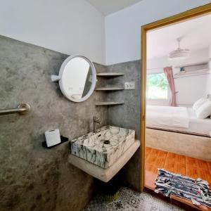 a bathroom with a sink and a mirror and a bed at Filou Studio Golf Pool Access 29 67 in Ko Chang