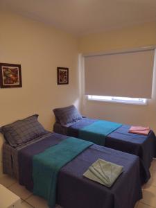2 camas en una habitación con ventana en Porto Real Resort Suites 1 en Mangaratiba