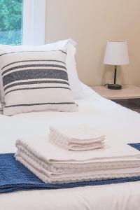 una pila de toallas en una cama con lámpara en Adorable 2-bedroom bungalow near Easton, Denton en Denton