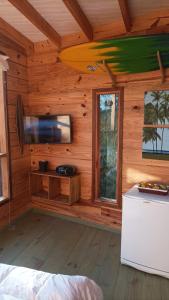 Blockhütte mit einem Bett und einem großen Fenster in der Unterkunft Del Bosque Surf Ranch in Villa Gesell
