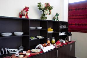 a kitchen with a counter with plates and food at Alegrias Inn Hotel in Cusco