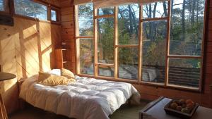 a bedroom with a bed in a room with windows at Del Bosque Surf Ranch in Villa Gesell +56 photos