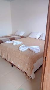 a bed with towels and a bow tie on it at Pousada Porto Tutóia in Tutóia +3 photos