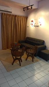 uma sala de estar com um sofá e uma mesa em Snoopy homestay Two Bedroom em Batu Pahat