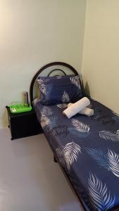 a bed with blue and white sheets and pillows at Snoopy homestay Two Bedroom in Batu Pahat