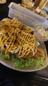 um prato de comida com uma sanduíche e batatas fritas em Snoopy homestay Two Bedroom em Batu Pahat