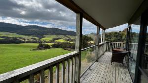 un balcón de una casa con vistas a las montañas en Mohua Park - Catlins Eco Accommodation en Owaka