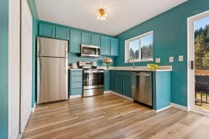 a kitchen with blue cabinets and stainless steel appliances at Adventure in Cle Elum in Cle Elum