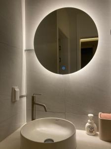 a bathroom with a sink and a round mirror at Dontan terrace in Hwaseong