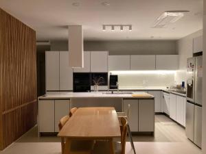 a kitchen with white cabinets and a wooden table at Dontan terrace in Hwaseong