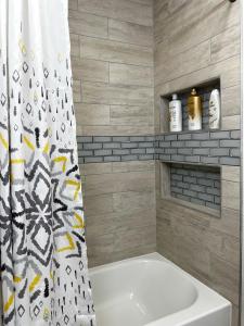 a bathroom with a tub and a shower curtain at Anchorage midtown apartment-Wyoming 2 in Anchorage