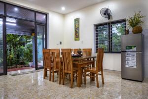 a dining room with a wooden table and chairs at VietnamTravel in Thái Nguyên