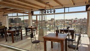 a restaurant with tables and chairs and large windows at Casa de Sal - Salt Hotel in Uyuni