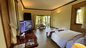 a bedroom with a bed and a flat screen tv at Garden Resort in Ko Chang