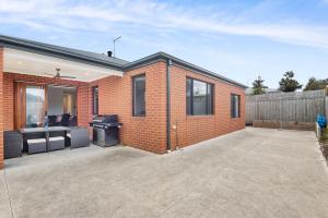 a brick house with a grill in a driveway at Beach Life in Indented Head