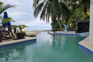 a pool at a resort with palm trees and a beach at Hotel y Restaurante Mama Ines in Santa Catalina