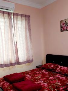 巴東勿剎的住宿－Rose Homestay Padang Besar，一间卧室设有红色的床和窗户。