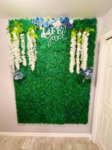 uma parede verde com flores e as palavras ajudam-no em Cozy Oasis near Disney! 4 bedroom 3 bath Townhouse! em Kissimmee