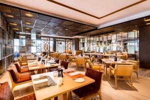 a restaurant with wooden tables and chairs at Crowne Plaza Vientiane by IHG in Vientiane