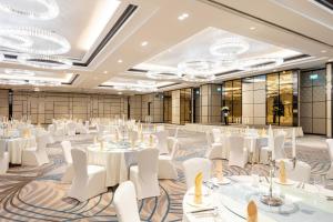 a ballroom with white tables and chairs and chandeliers at Crowne Plaza Vientiane by IHG in Vientiane +37 photos