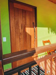 a wooden door in a room with a bench at Recanto do Loriano in Monte Verde