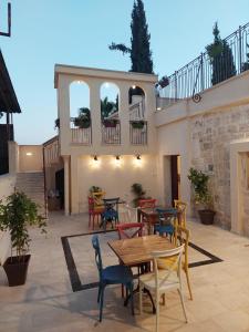 a patio with tables and chairs and a balcony at Reeja art gallery in Nazareth