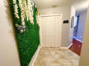 um corredor com uma parede verde com flores brancas em Cozy Oasis near Disney! 4 bedroom 3 bath Townhouse! em Kissimmee