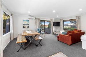 a living room with a red couch and a table at North South Holiday Park in Christchurch