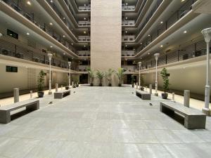 un hall vide avec bancs et plantes en pot dans l'établissement Imperial Suites at Boulevard Mall, à Kuching
