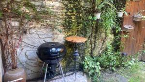 a table and stool next to a wall with plants at 小古堡民宿 The Little Castle - 完成訂房後務必要與屋主聯絡確認 in Tainan