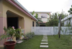 Posada Mango House في سان أندريس: حديقة خلفية لبيت به سياج أبيض