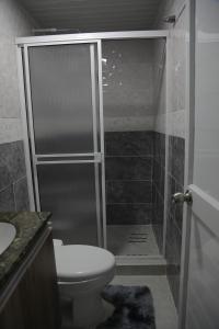 ein Bad mit einer Dusche, einem WC und einem Waschbecken in der Unterkunft Posada Mango House in San Andrés