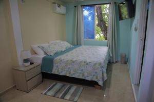 Habitación pequeña con cama y ventana en Posada Mango House en San Andrés