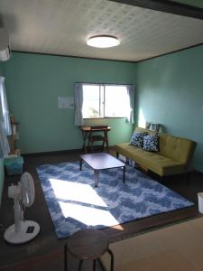 - un salon avec un canapé et un tapis dans l'établissement Minami Onna Tropical, à Onna