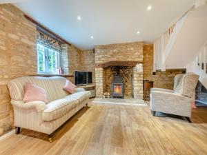 a living room with a couch and a fireplace at Patience Cottage in Idbury