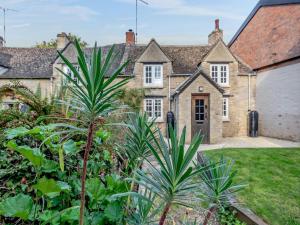 an old house with a garden in front of it at Patience Cottage in Idbury