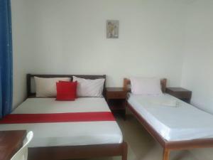 twee bedden in een kamer met rode kussens erop bij PEDRO'S RESORT in Panglao