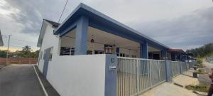 a blue and white building with a fence at Homestay D'Mama Īfor mūslimĪ in Tanjung Malim